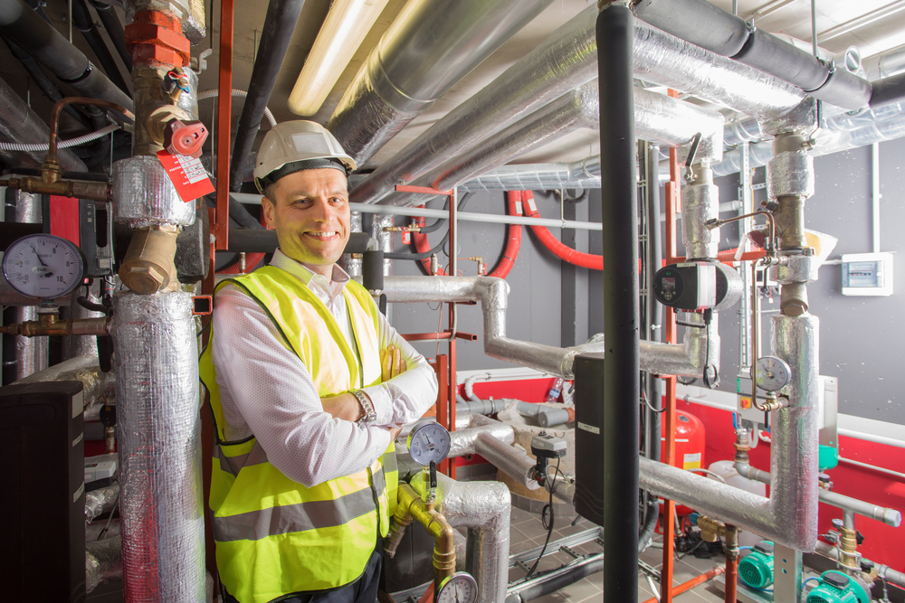 Glad man står nere i ett pannrum